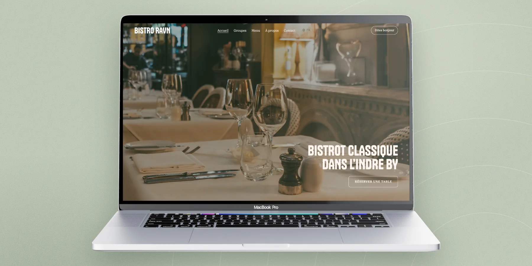 La page d'accueil du Bistro Ravn sur un ordinateur portable : une photo de la salle, le titre « Bistrot classique dans l’Indre By » et un bouton Réserver une table