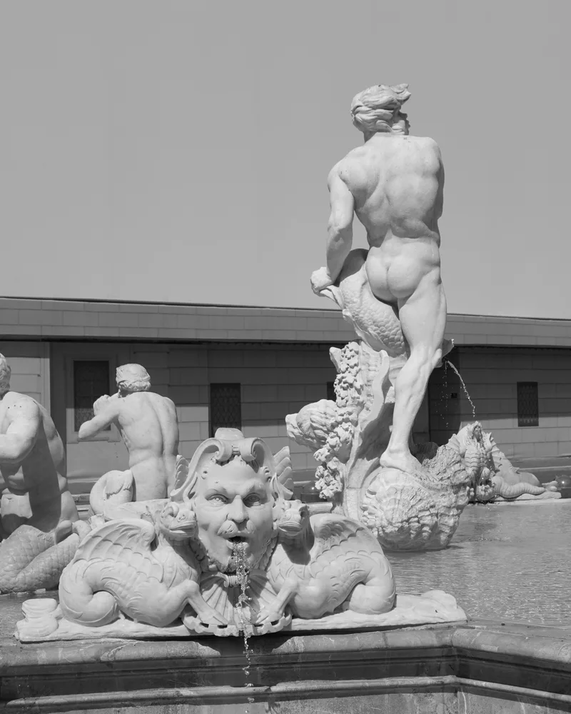 Et springvand i marmor med en stående figur og udhuggede havvæsner.